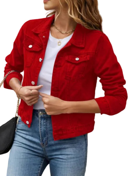 Person wearing a red denim jacket over a white shirt and blue jeans, standing against a beige wall.