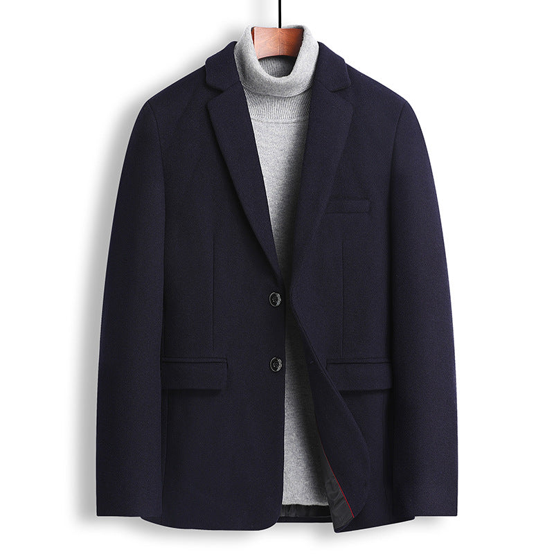 A men's dark navy blue blazer styled over a light gray turtleneck sweater, hanging on a wooden hanger against a plain white background.