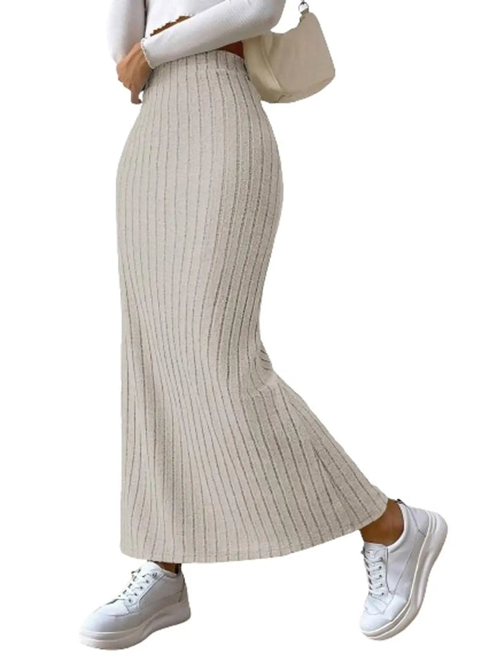 Person wearing a beige ribbed knit skirt with white sneakers on a white background