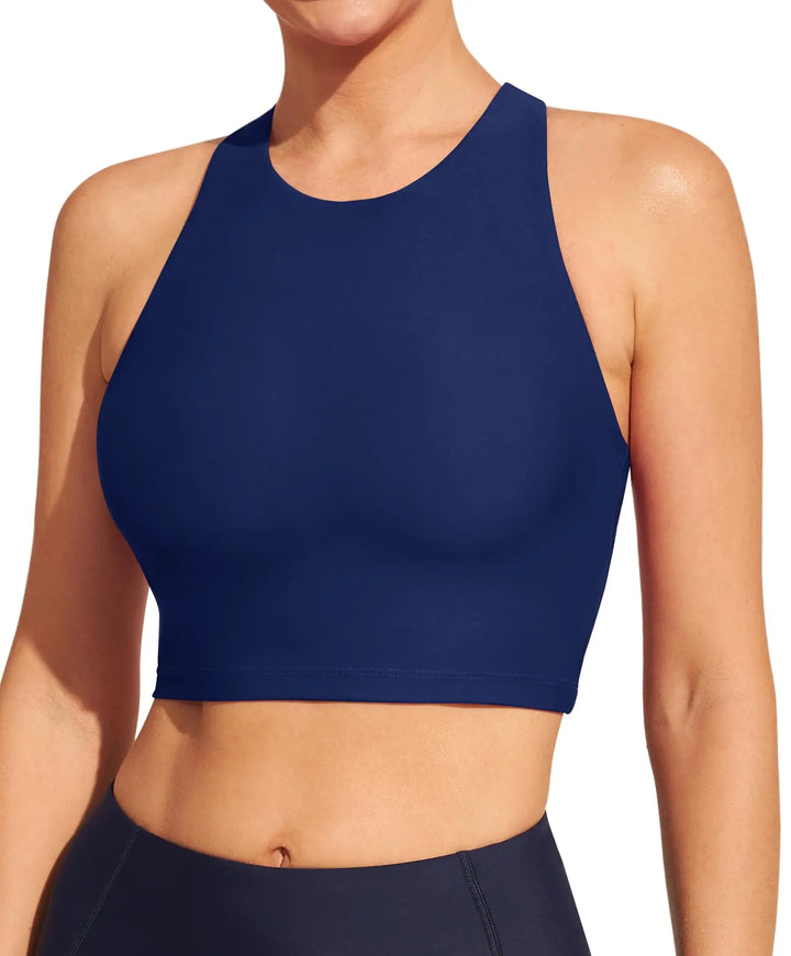 A woman wearing a navy blue high-neck crop top and matching navy bottoms, shown from the neck to the waist against a plain white background.