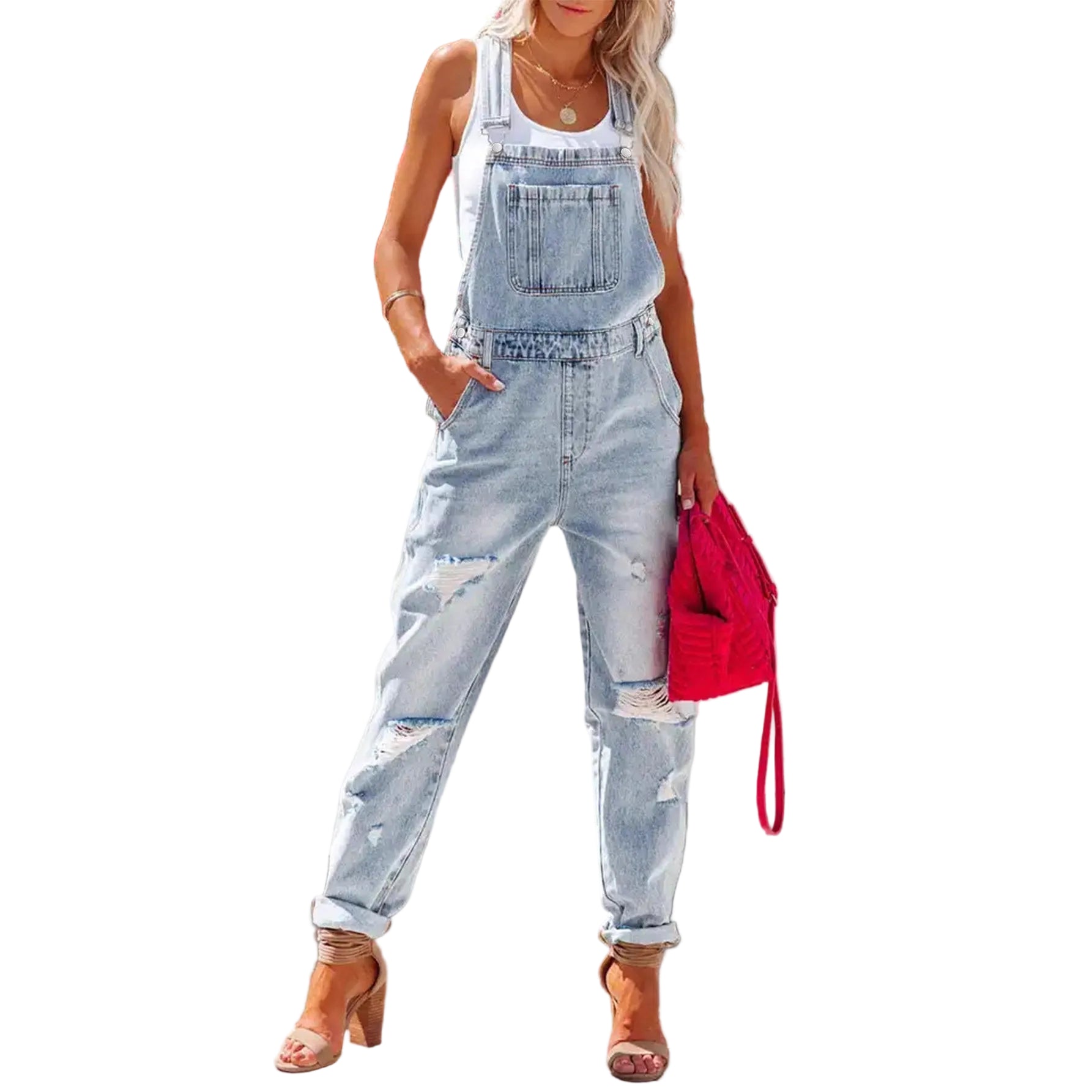 Woman wearing light blue denim overalls with a red handbag in front of pink flowers.