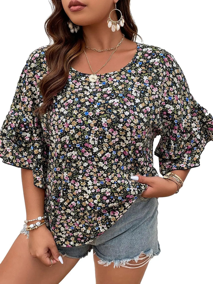 Woman wearing a floral blouse with denim shorts on a white background
