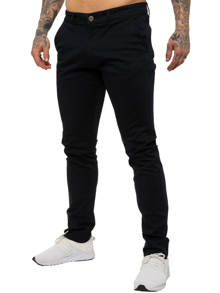 Person wearing black pants and white sneakers on a white background