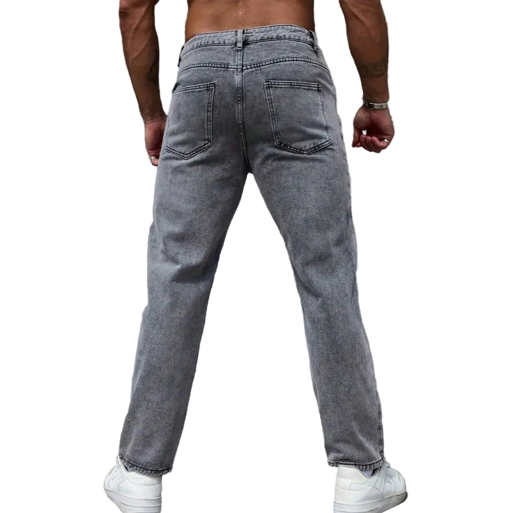 A person shown from the back wearing light gray washed denim jeans and white sneakers, standing against a textured gray wall.
