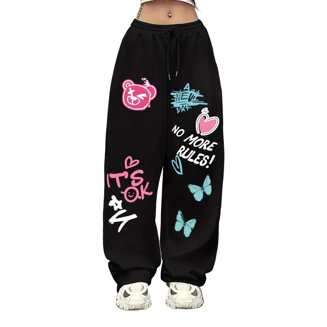 Black wide-leg sweatpants with colorful graphic prints including pink, blue, and white designs, worn by a model with white sneakers.