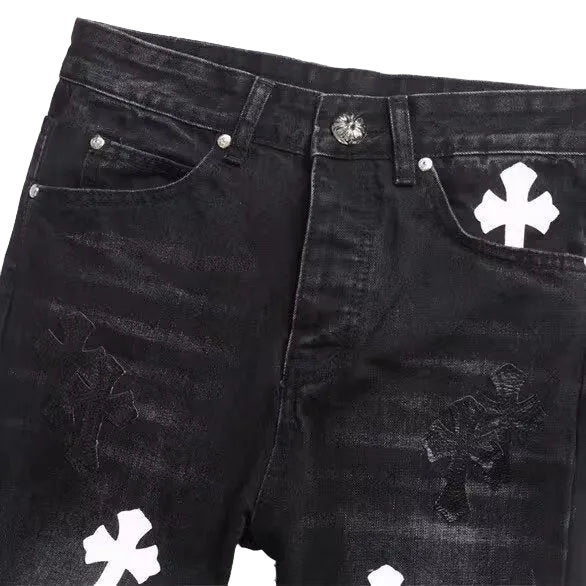 Black washed denim jeans with distressed details and white embroidered cross motifs on the pockets and legs.