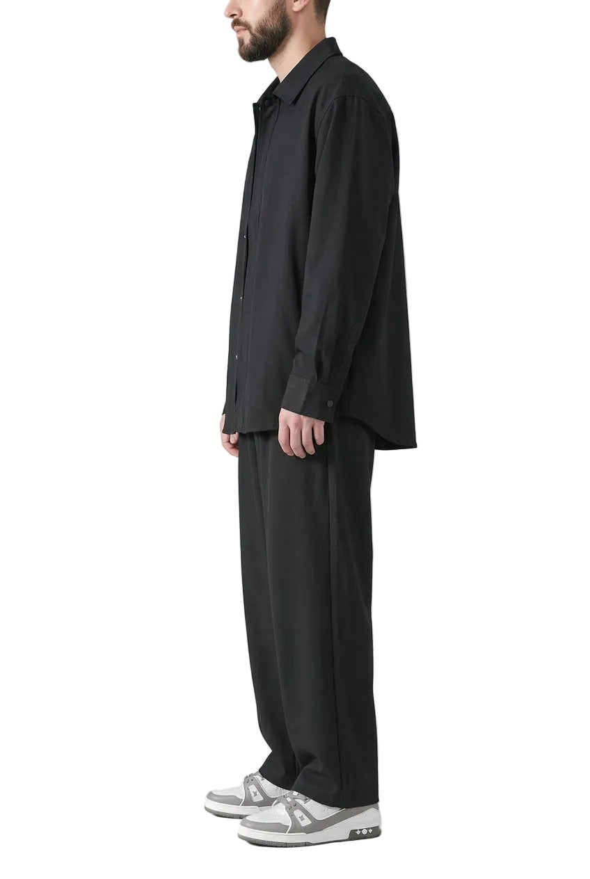 Person wearing black wide-leg pants and white sneakers on a gray background