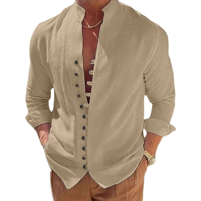 Man wearing a beige cardigan over a red shirt on a white background