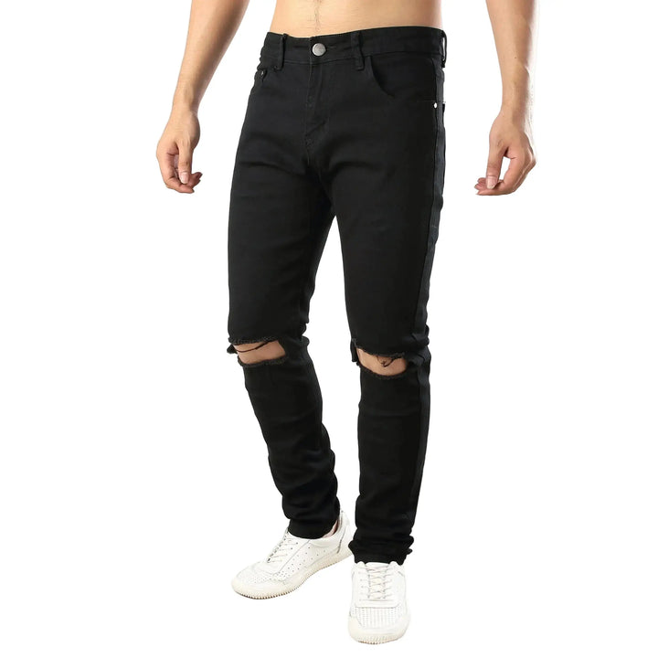 Black ripped jeans worn by a person on a white background