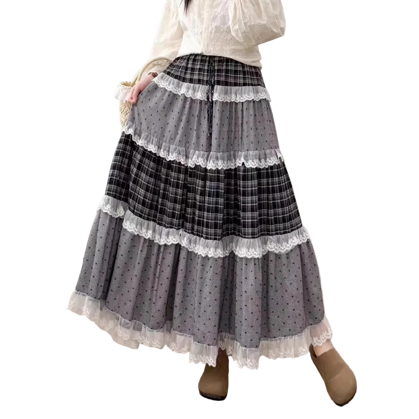 Person wearing a layered skirt with plaid and polka dot patterns in a room.