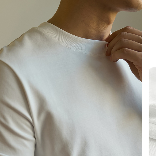 Close-up of a person wearing a plain white short-sleeve crew-neck T-shirt, with the hand adjusting the collar.