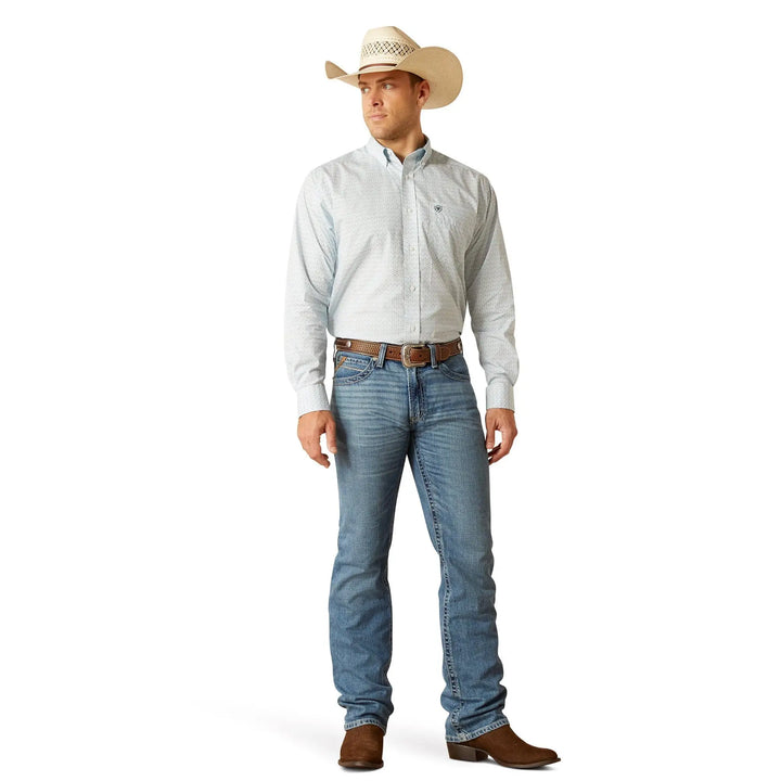 A man modeling a light blue and white striped long-sleeve western shirt, blue jeans, a brown belt, brown boots, and a beige cowboy hat against a white background.