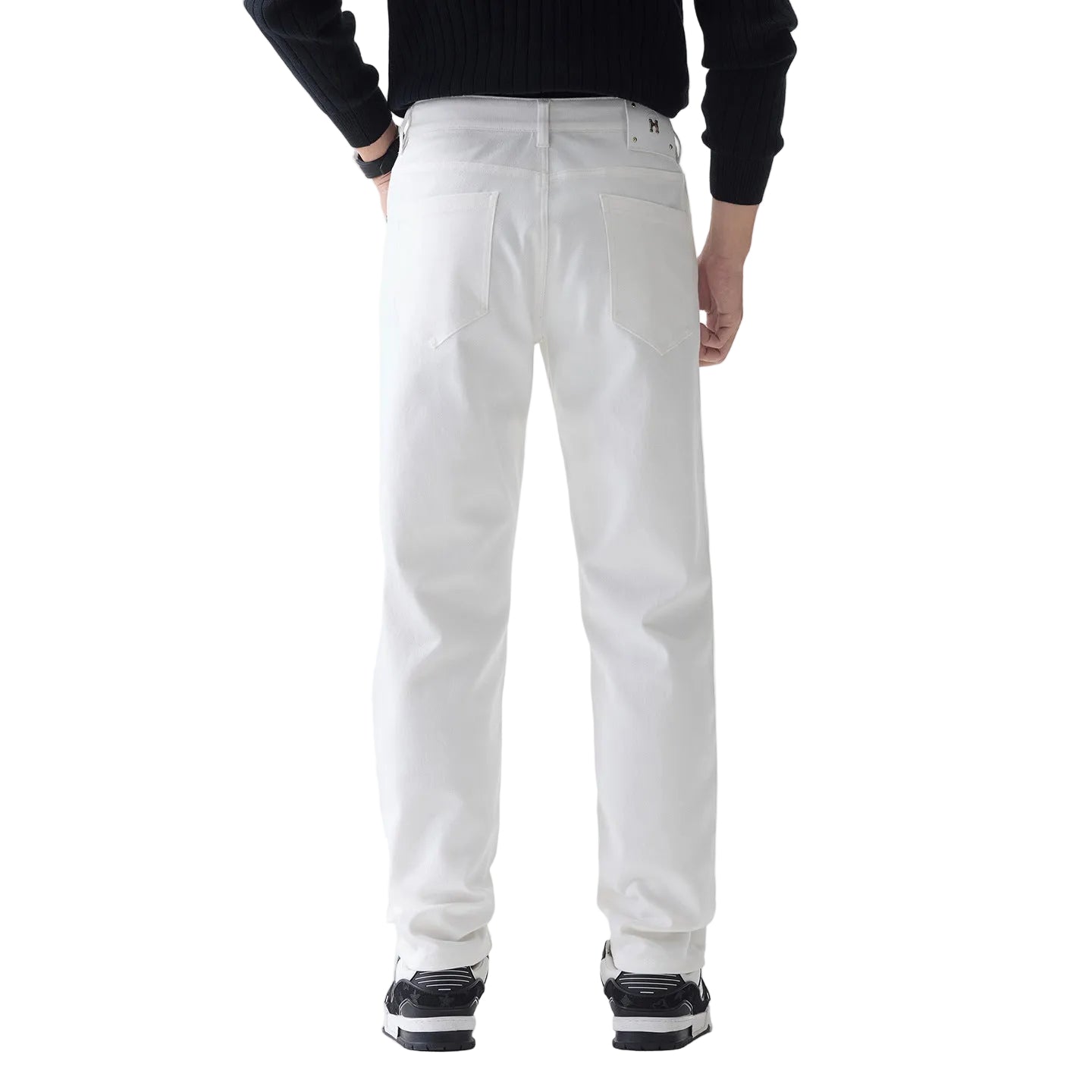 A person shown from the back wearing white straight-leg jeans, a black ribbed long-sleeve top, and black-and-white sneakers against a clean white studio background.