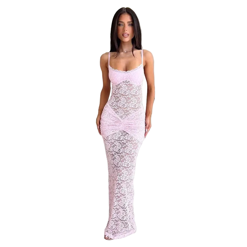 Woman in a pink lace dress standing in a modern living room.