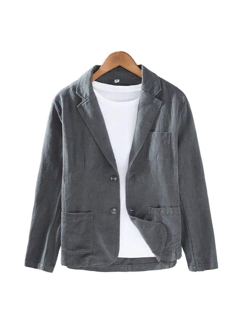 A dark gray linen-blend blazer jacket with notch lapels and front buttons, styled over a white t-shirt on a wooden hanger against a textured gray wall.
