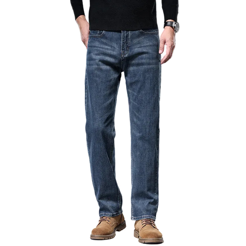 Person wearing blue jeans and brown shoes on a gray background