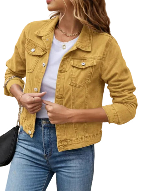 Person wearing a mustard yellow jacket and blue jeans against a neutral wall.