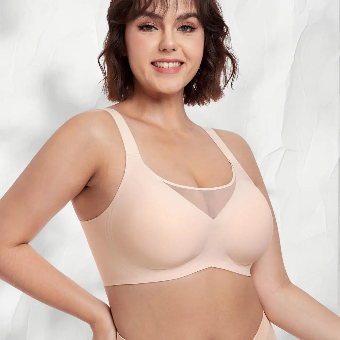 Woman wearing a beige bra against a white background