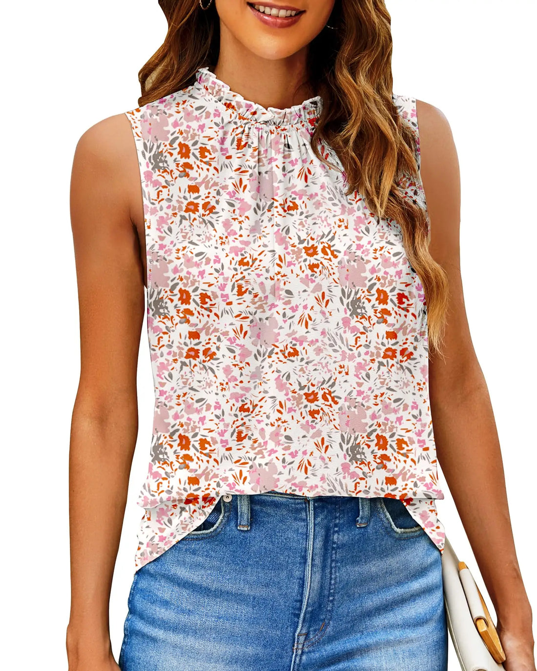 A woman wearing a sleeveless high-neck blouse with a pink, orange, and gray floral pattern on a white background, paired with blue jeans.