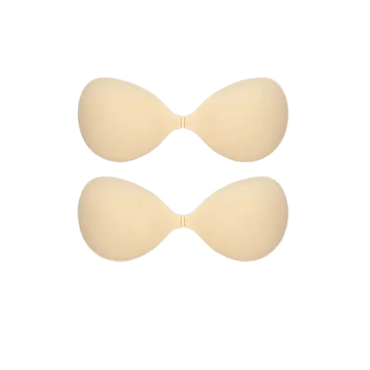 Two beige silicone adhesive bra cups shown on a plain white background.