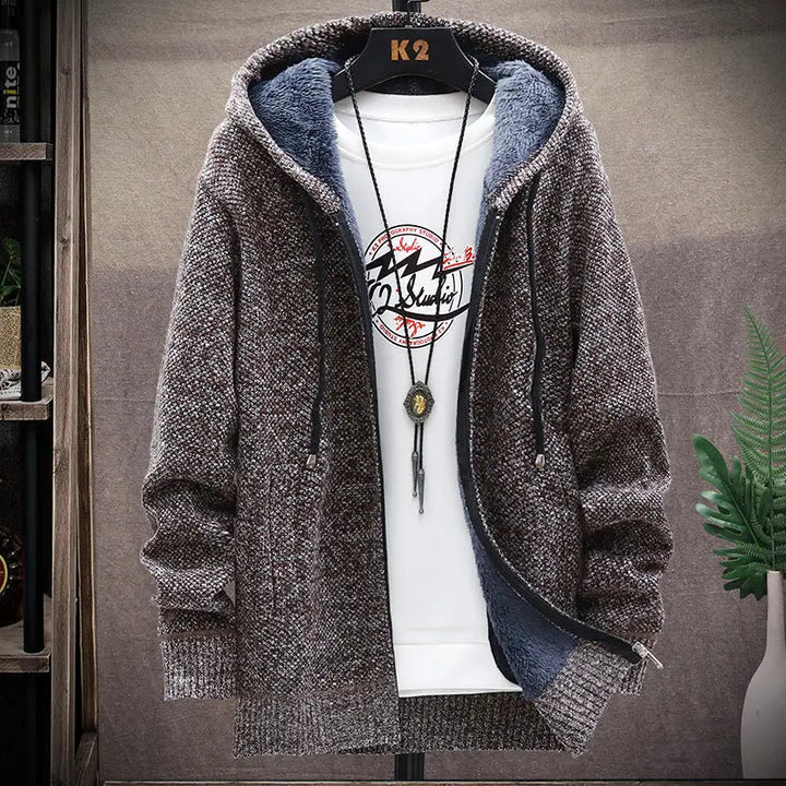 Brown hooded jacket on a hanger with a white shirt underneath, against a neutral background.