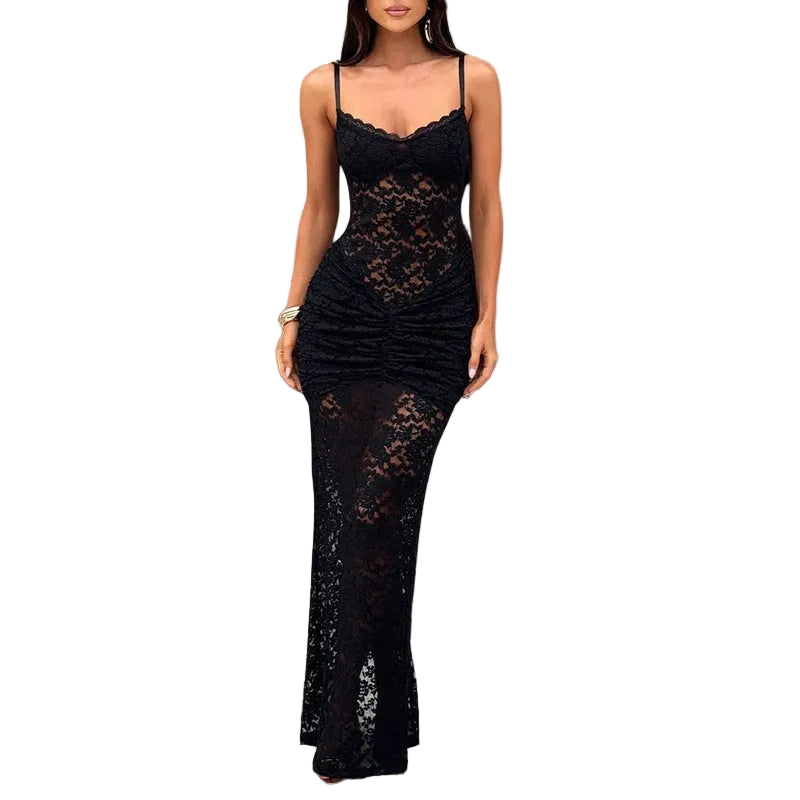 Woman wearing a black lace dress in a room with white walls and a textured floor.