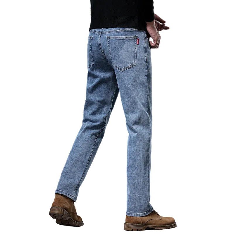 Person wearing blue jeans and brown boots on a gray background