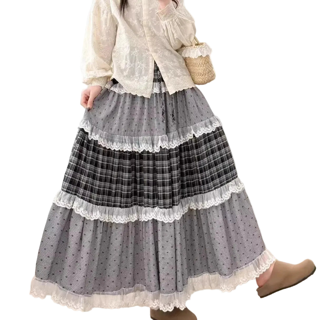 Person wearing a layered skirt with plaid and lace details in a room.