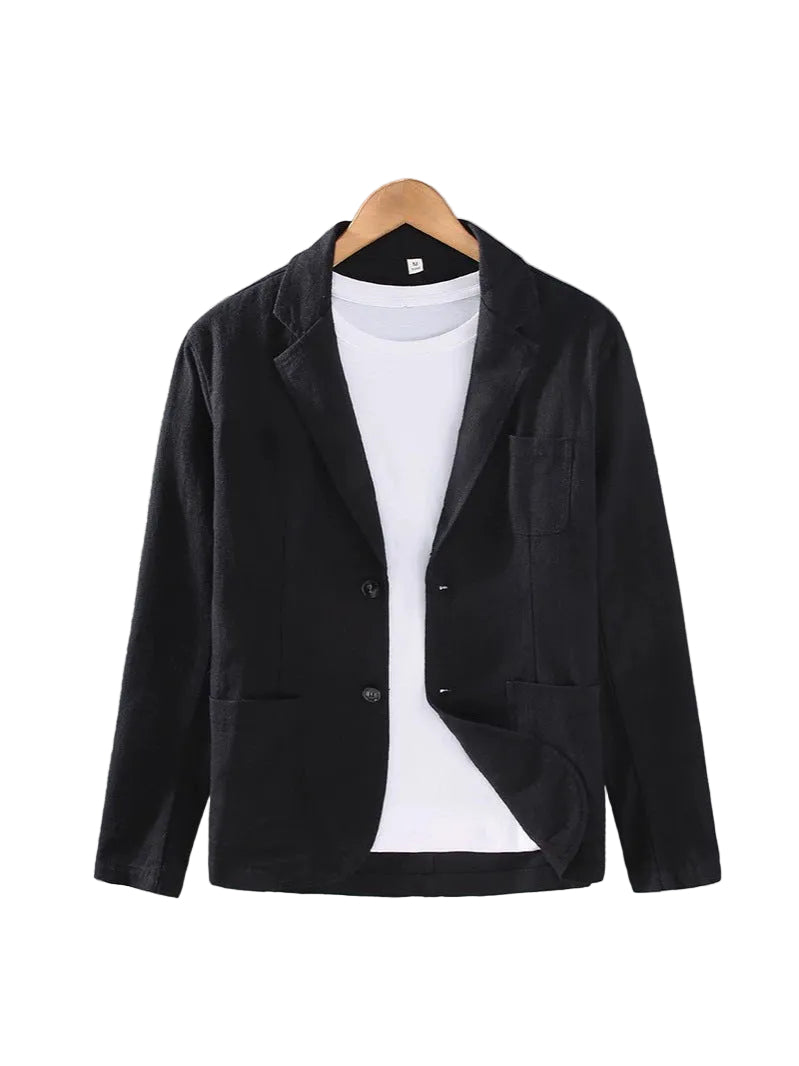 A black long-sleeve blazer jacket styled over a white t-shirt, hanging on a wooden hanger against a textured gray wall.
